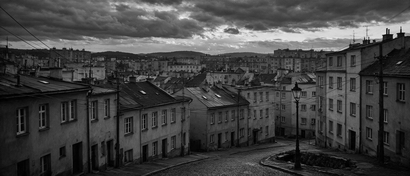 Krovovi i ulice manjeg grada u sumrak, crno-bela fotografija